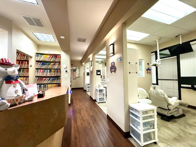 Hallway view showing dental operatory rooms and patient-friendly decor